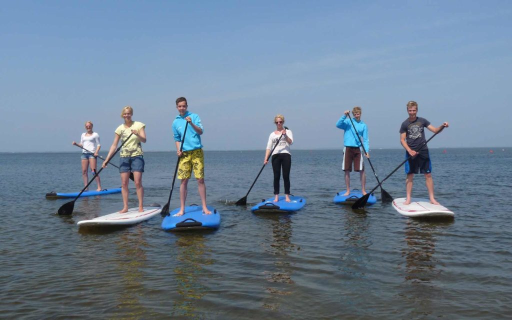 Eine Gruppe von Kindern stehen auf Surfbrettern